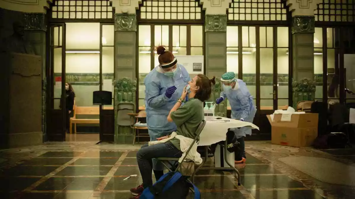 Una professional sanitària realitzant una prova a una pacient durant un cribratge a Barcelona