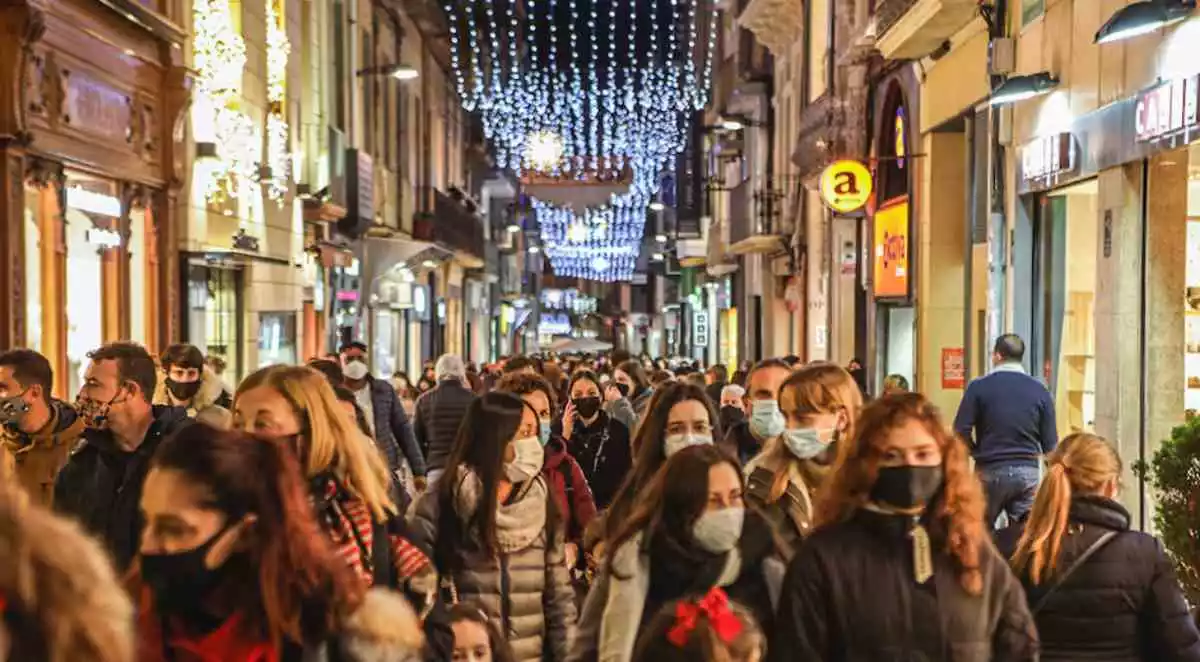 Imatge d'un carrer de Reus ple de gent fent compres durant les festes de Nadal