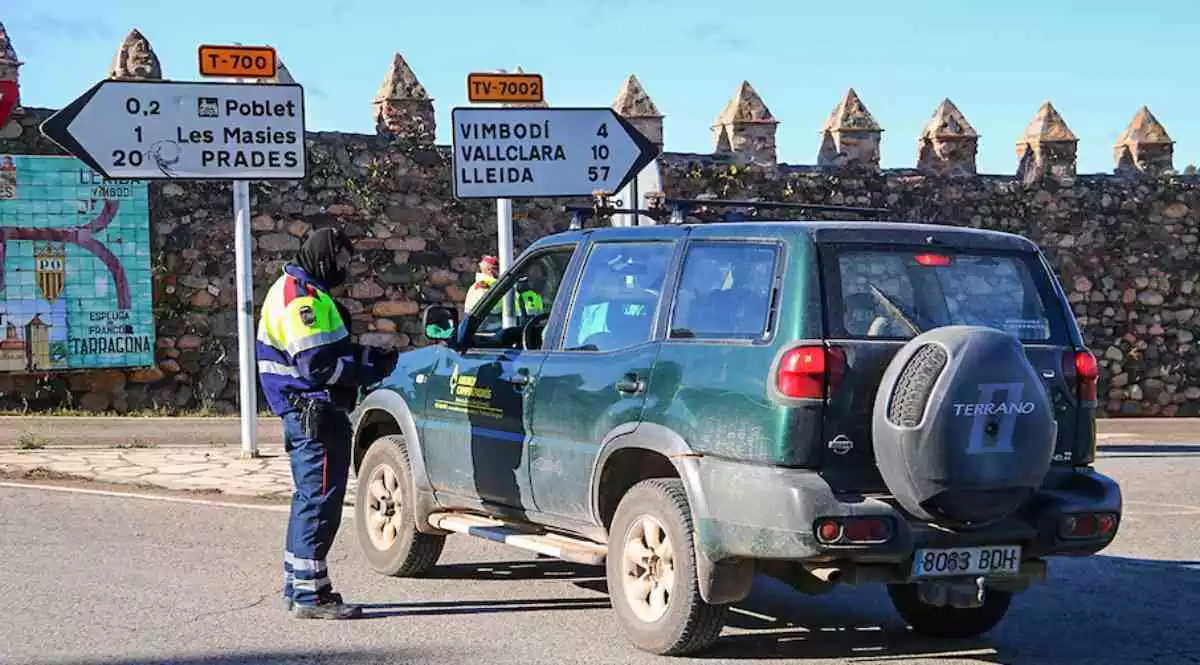 Pla obert d'un agent dels Mossos d'Esquadra comprovant la documentació d'un conductor al control policial fet a la carretera T-700 a Vimbodí i Poblet.