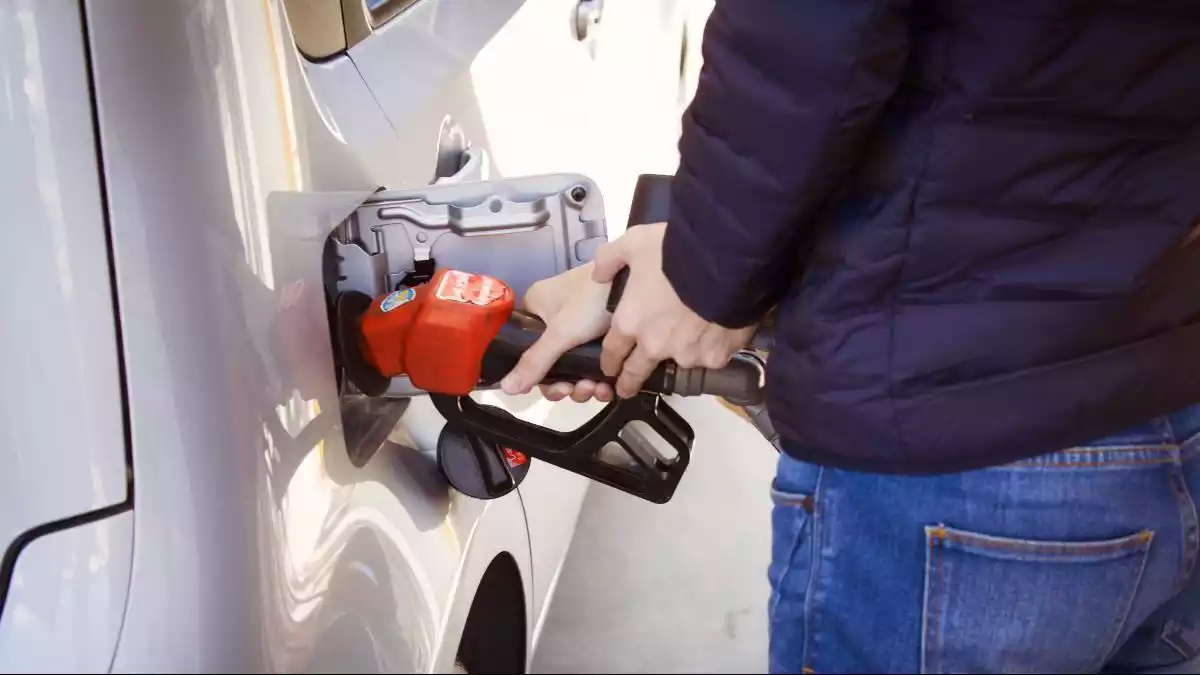 Una persona posa combustible al seu cotxe