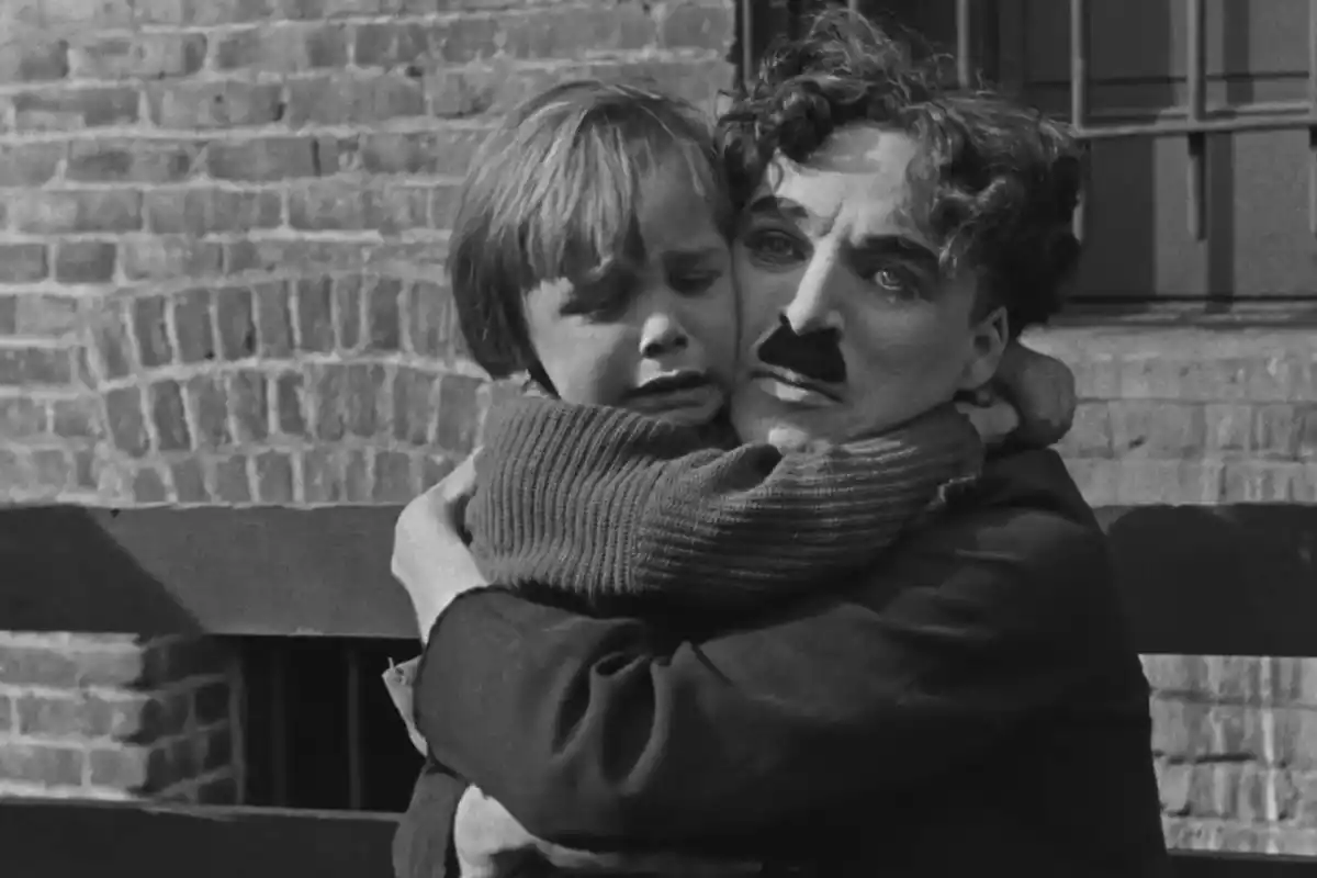 Charles Chaplin abraça Jackie Coogan en una escena de 'El chico'