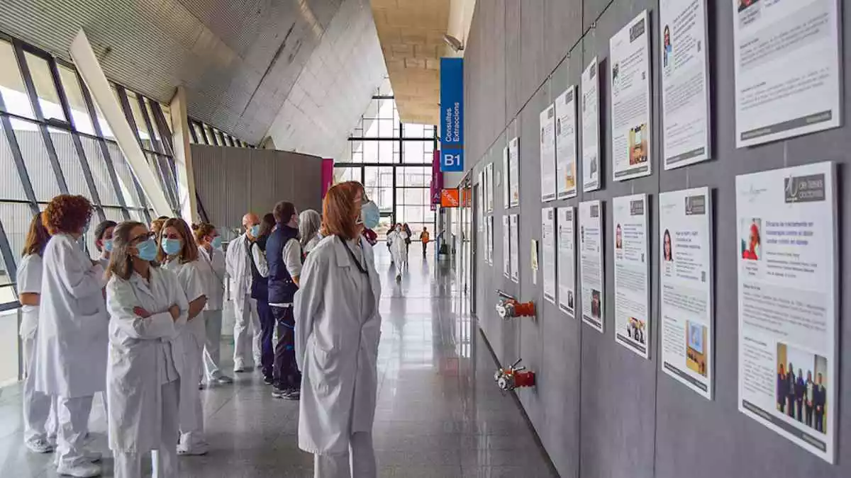 Imatge de diverses professionals sanitàries observant la mostra sobre les tesis doctorals a l'Hospital Sant Joan de Reus
