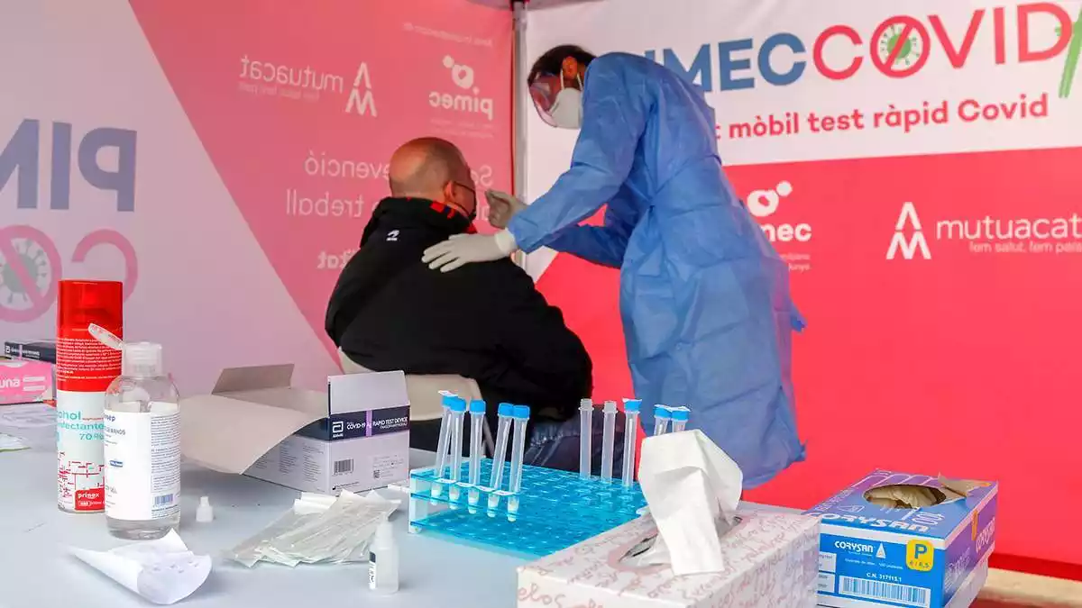 Imatge d'un professional sanitari fent un test de coronavirus a un treballador