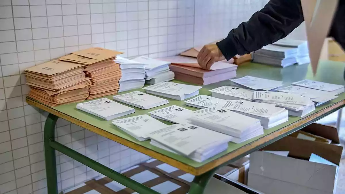 Imatge d'una persona agafant una papereta electoral en una jornada d'eleccions