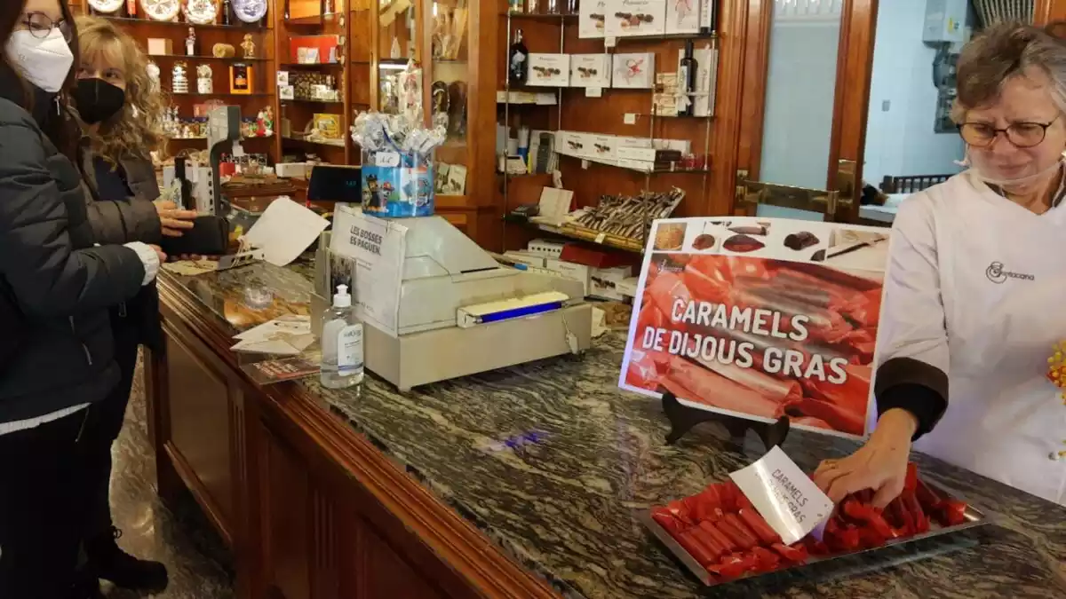 Pla general d'unes dones comprant caramels de Dijous Gras a la pastisseria Santacana de Valls
