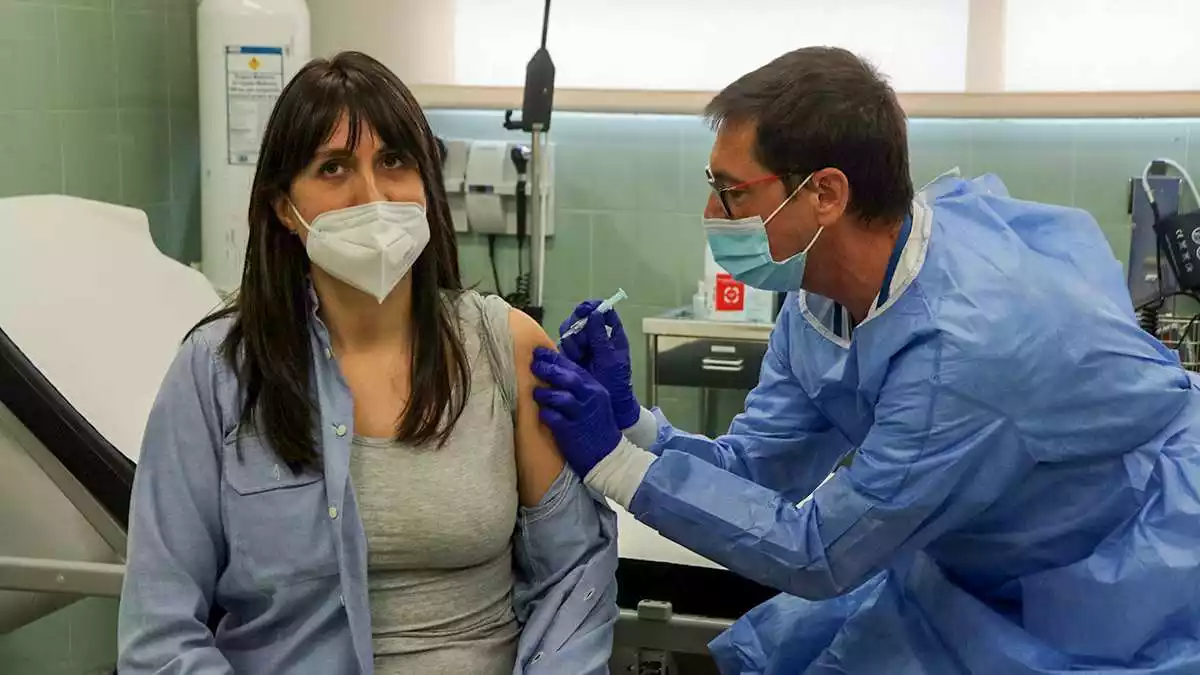 Pla mitjà de la Mireia, una treballadora del centre penitenciari de Mas d'Enric rebent la primera dosi de la vacuna d'AstraZeneca a la infermeria de la presó