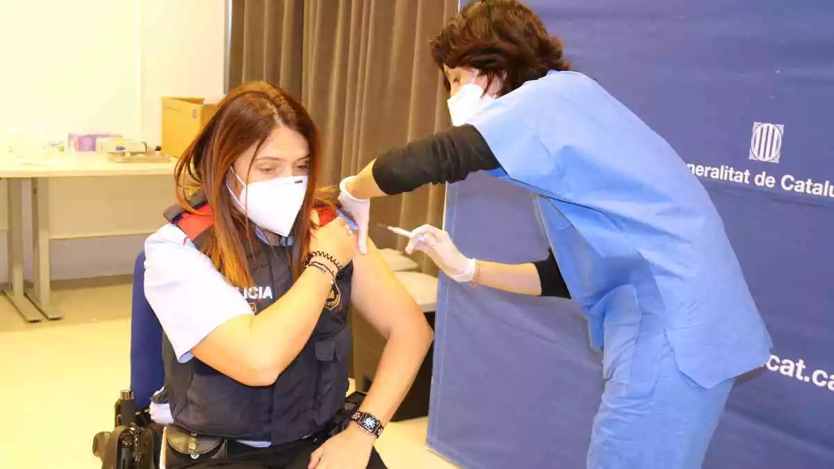 Pla mitjà d'una agent dels Mossos d'Esquadra rebent uan dosi de la vacuna d'AstraZeneca a la comissaria de Tortosa