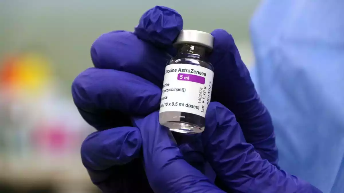 Primer pla d'una ampolleta de la vacuna contra la covid-19 d'AstraZeneca, que conté deu dosis, a les mans d'un infermer