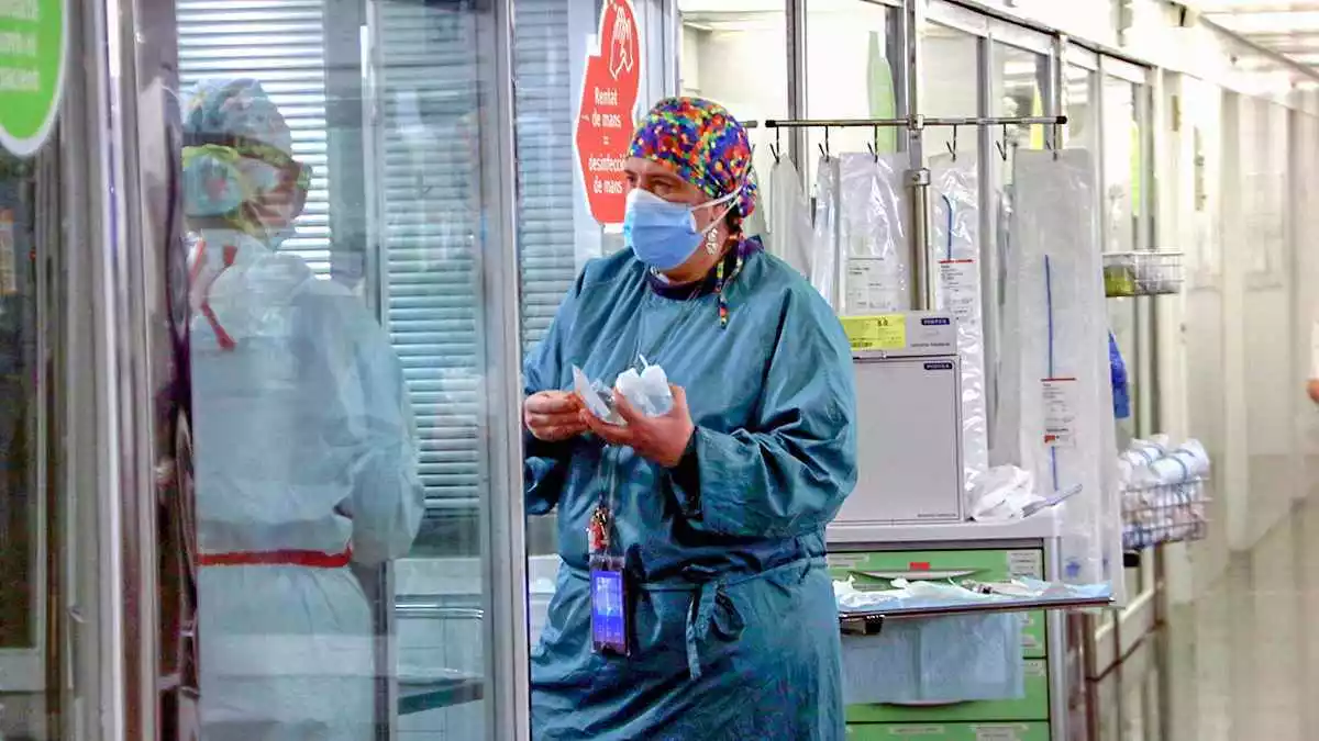Sanitària portant material a una companya en una UCI de l'Hospital del Mar amb pacients Covid-19, en la tercera onada de la pandèmia del coronavirus