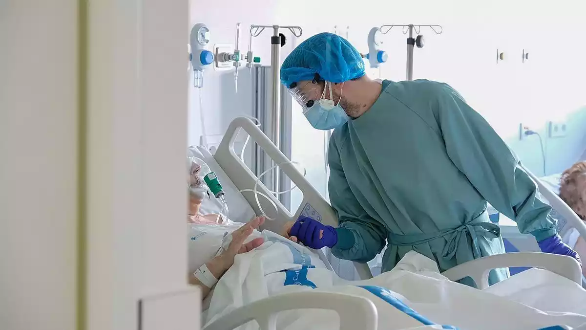 Un professional sanitari atén un pacient al nou espai polivalent de l'Hospital de Bellvitge