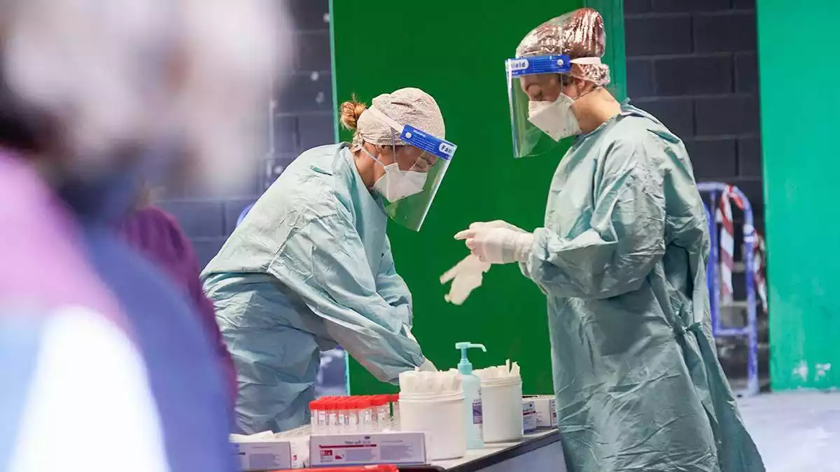 Imatge de dues sanitàries preparant el material per realitzar tests d'antígens