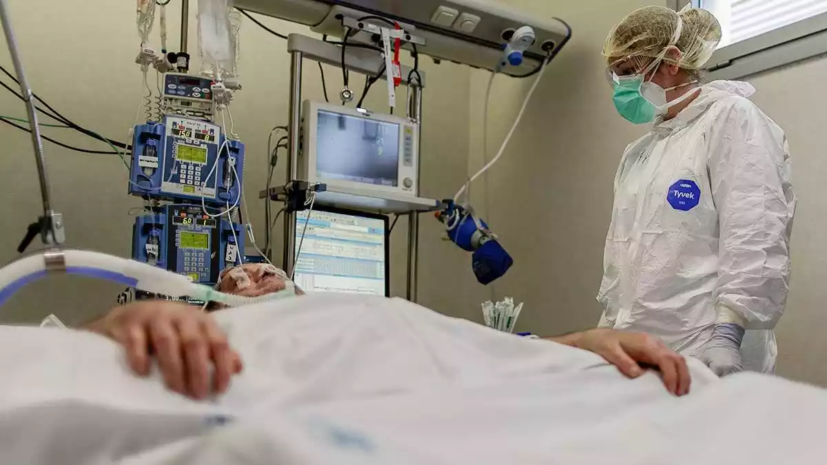 Imatge d'un professional sanitari atenent un pacient crític amb coronavirus en un hospital madrileny