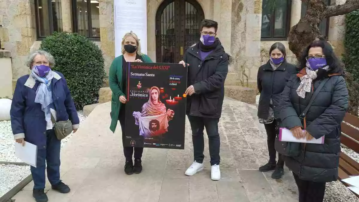 Membres de la Verònica de Reus i Montserrat Caelles mostren el cartell d'enguany