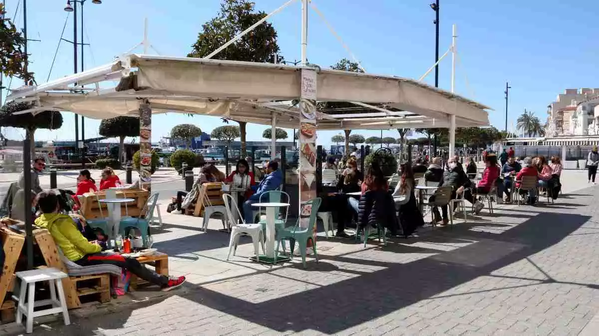 Pla general de persones assegudes a les terrasses dels bars del passeig marítim de Cambrils