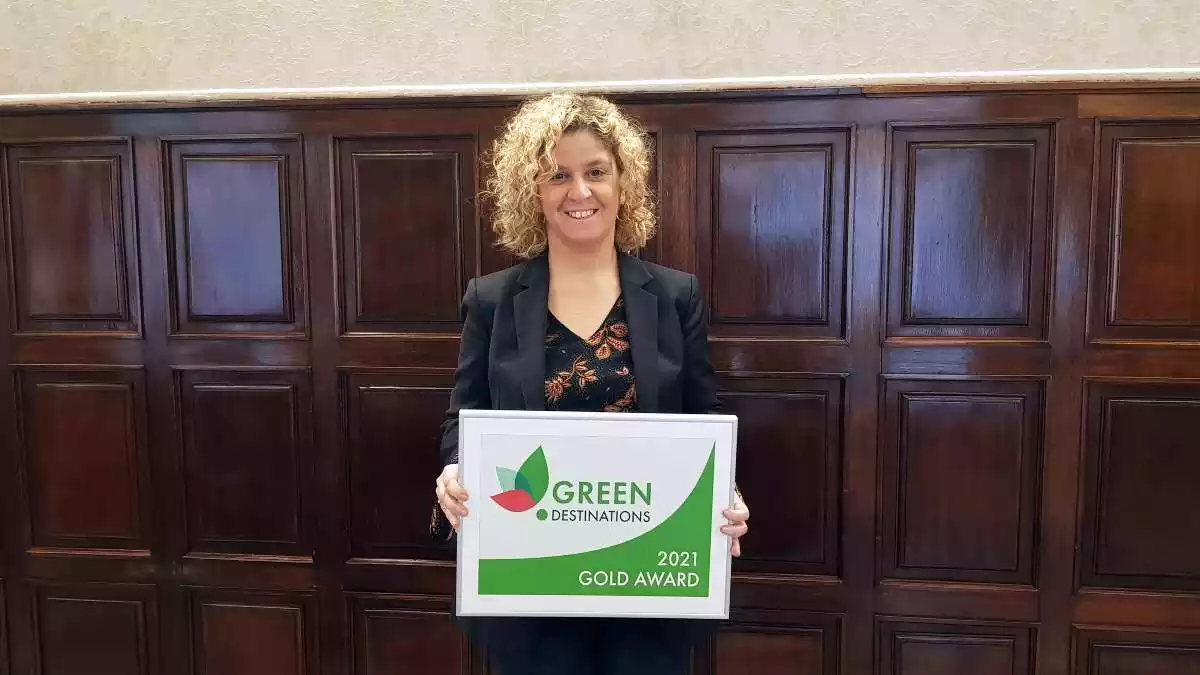 Pla mitjà de la presidenta del Patronat de Turisme de la Diputació, Meritxell Roigé, mostrant el diploma del guardó dels Green Destinations Award