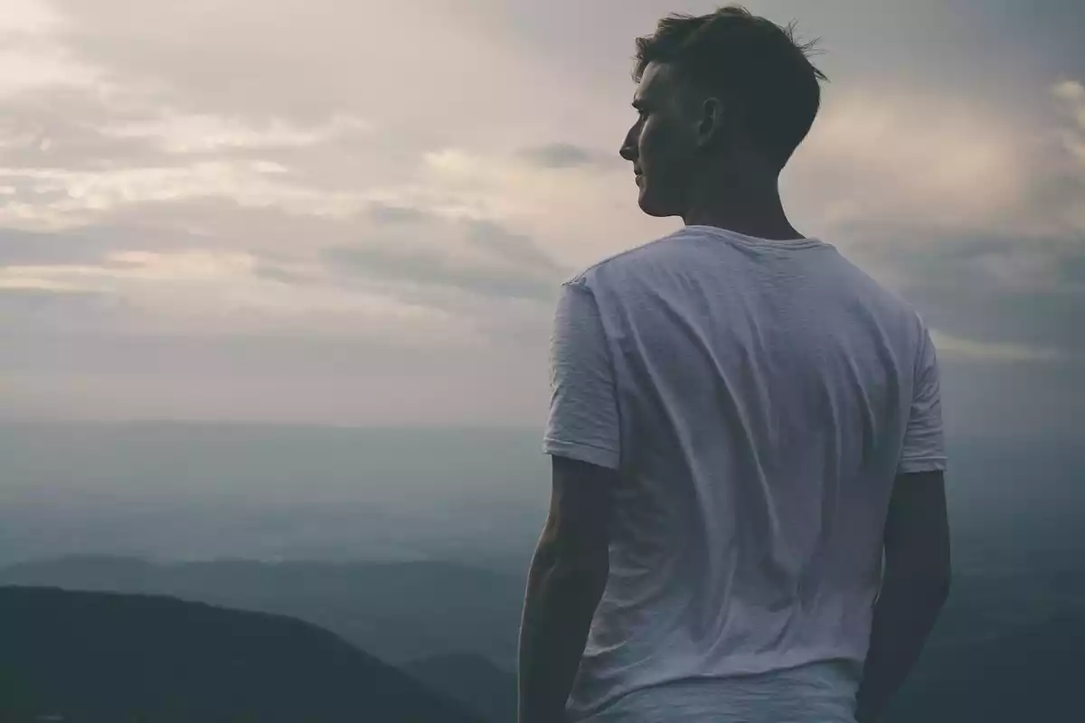 Un home mirant el paisatge des de dalt d'una muntanya