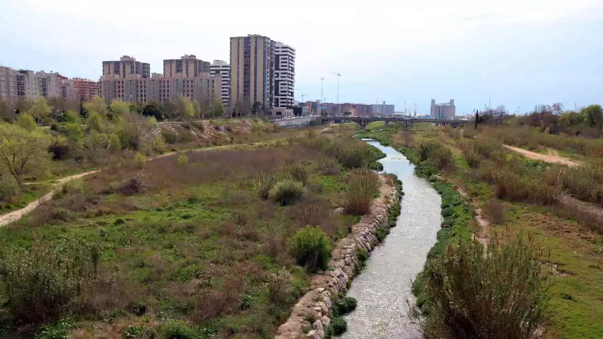 Un tram del riu Francolí al seu pas per la ciutat de Tarragona amb un mur empedrat i molt poca vegetació de ribera
