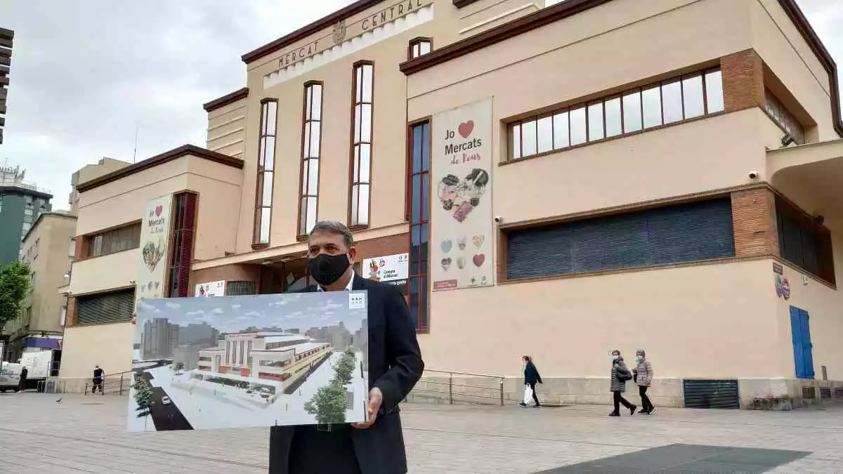 Carles Prats sosté una imatge virtual de la nova façana del Mercat Central davant de l'edifici