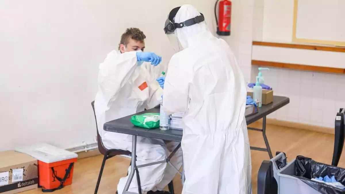 Imatge de dos professionals sanitaris preparant proves PCR durant el cribratge al barri de Bonavista