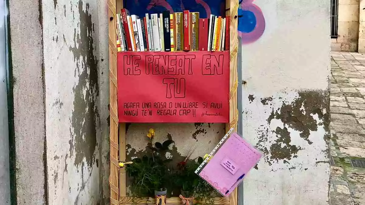 Imatge de la prestatgeria amb llibres i roses de la iniciativa «La rosa ets tu», a la Part Alta de Tarragona