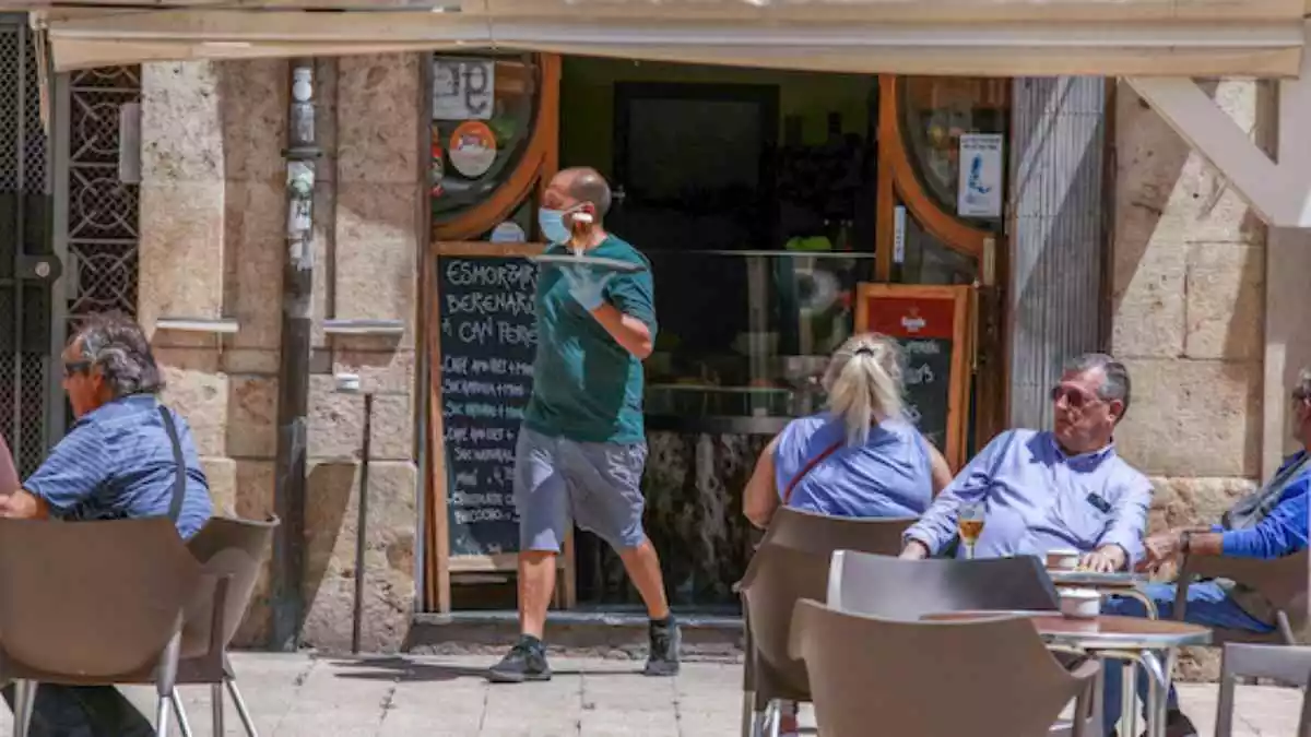 Imatge d'un cambrer amb mascareta servint a la terrassa d'un bar de la plaça de la Font de Tarragona