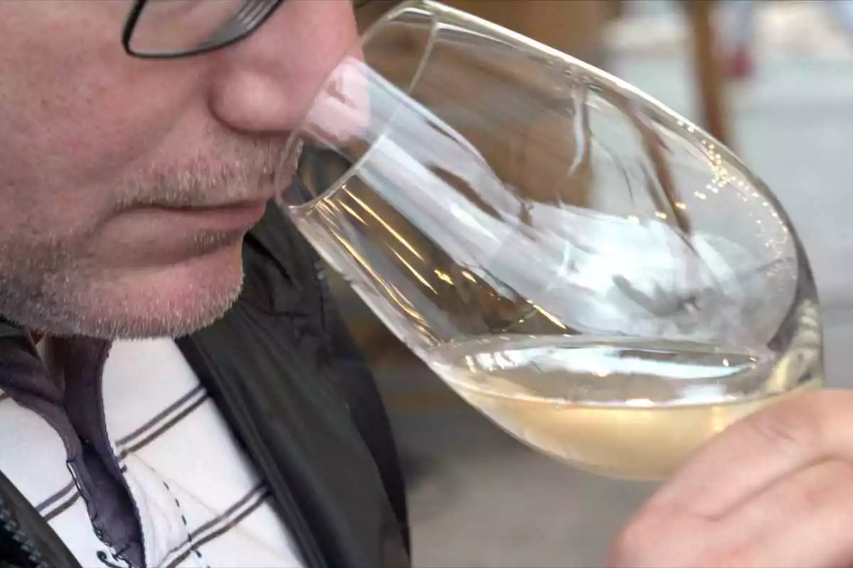 Imatge d'una persona tastant un vi blanc