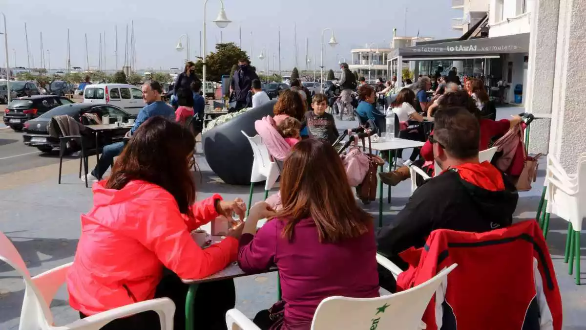 Persones consumint en una terrassa d'un bar de la zona marítima de l'Ampolla aquesta Setmana Santa