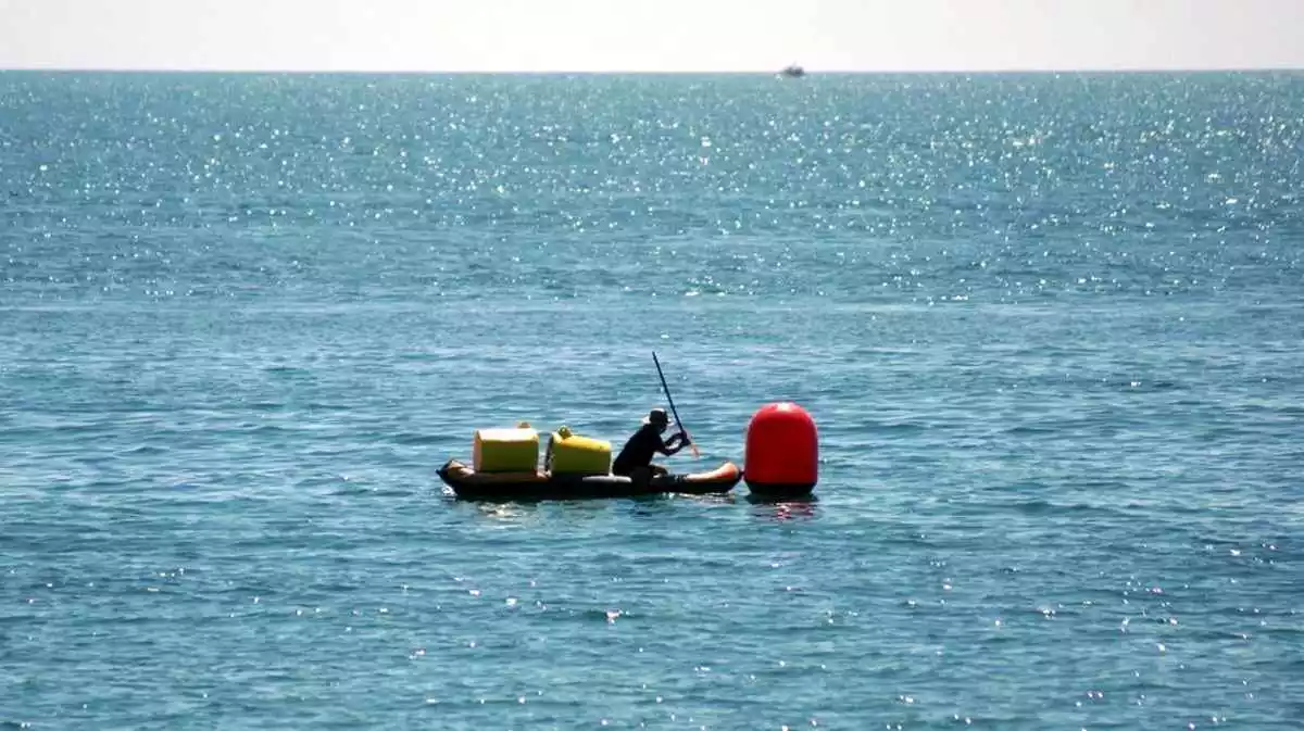 Una embarcació al costat d'una de les boies que engoleixen microplàstics instal·lades a les platges de l'Ampolla