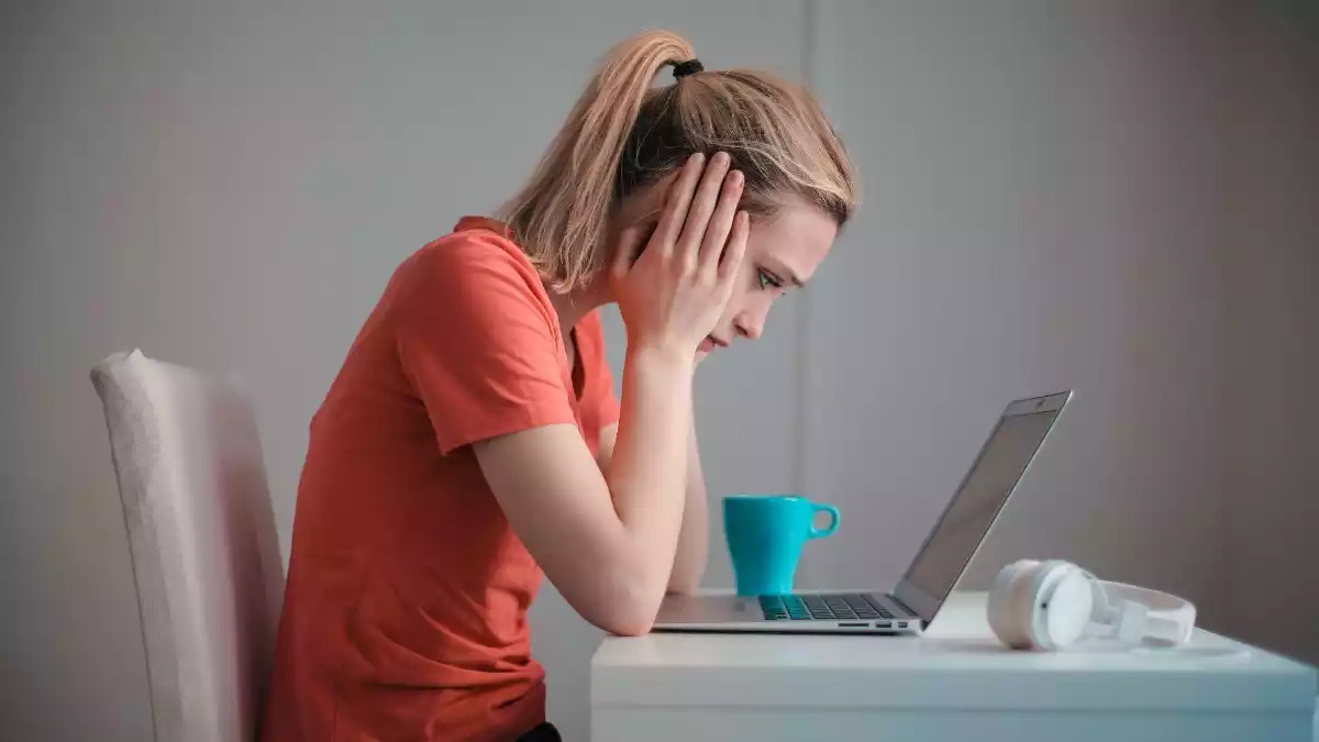 Imatge d'arxiu d'una noia amb actitud de preocupació davant d'un ordinador portàtil
