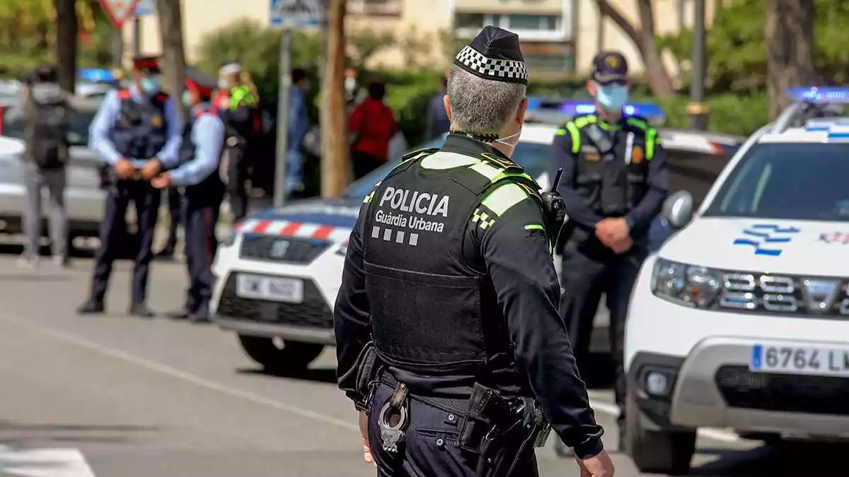 Imatge d'un agent de la Guàrdia Urbana de Tarragona d'esquenes, amb diversos agents de la policia tarragonina i els Mossos al darrere