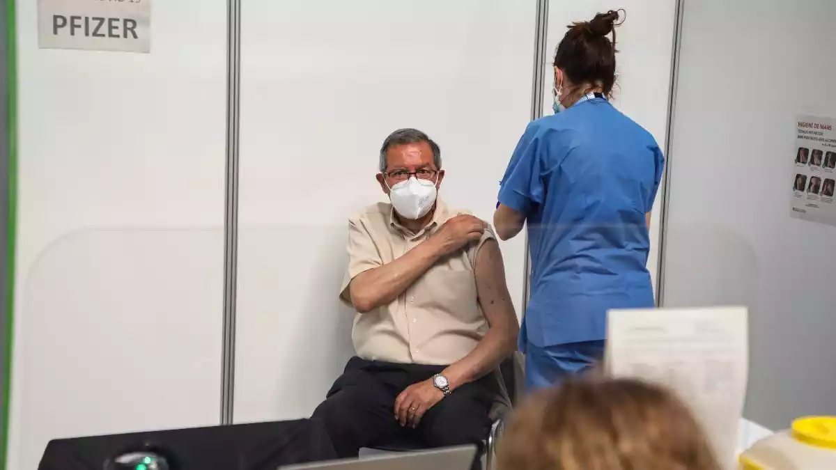 Imatge d'una professional sanitària a punt d'administrar la vacuna contra la Covid-19 a un ciutadà