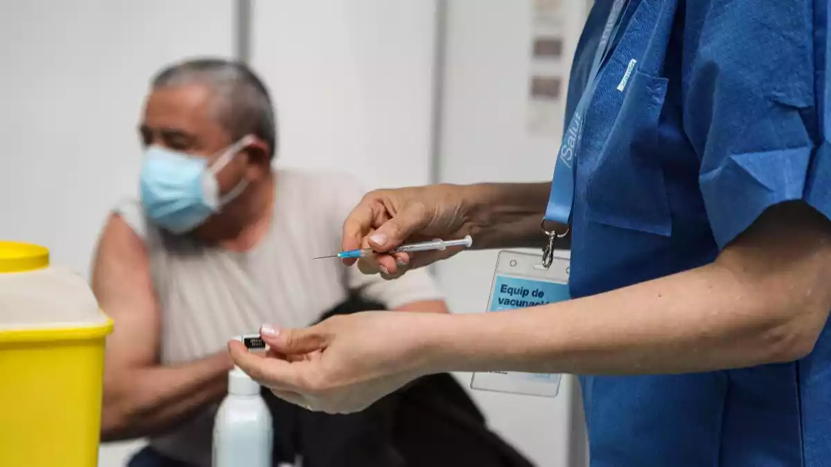Imatge d'una professional sanitària preparant una dosi de la vacuna contra la Covid-19 per administrar-la a un ciutadà