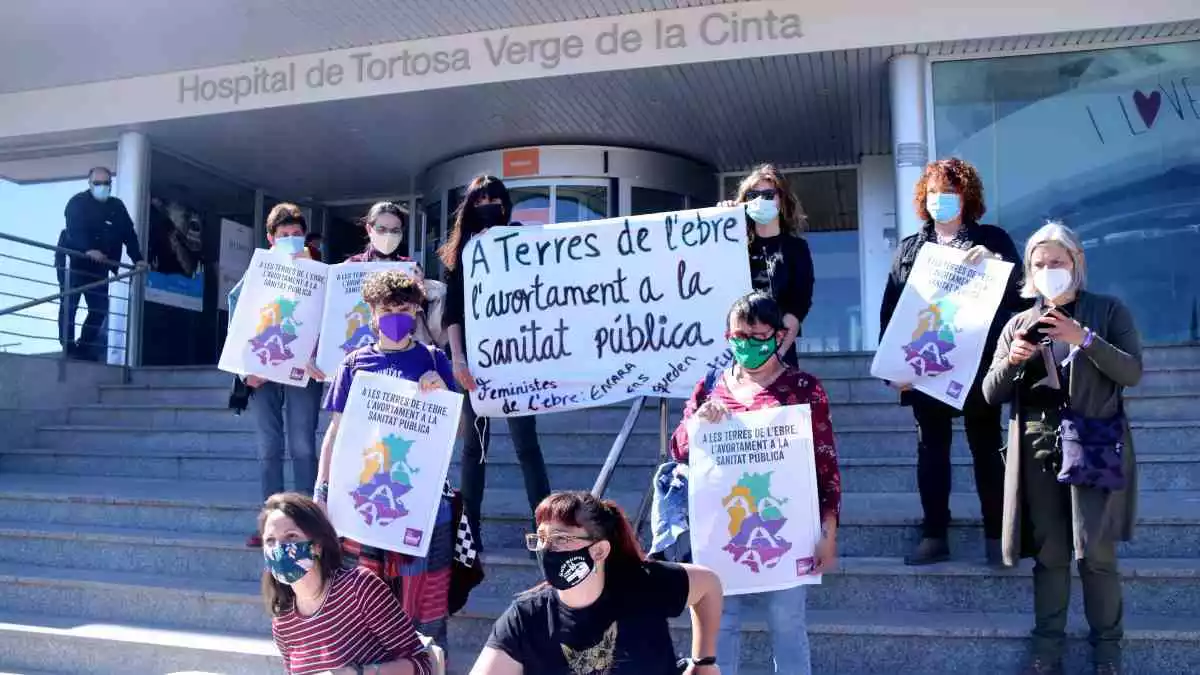 Membres de l'Assemblea Vaga Feminista de les Terres de l'Ebre amb cartells de la campanya per l'avortament quirúrgic voluntari a les escales de l'Hospital de Tortosa Verge de la Cinta