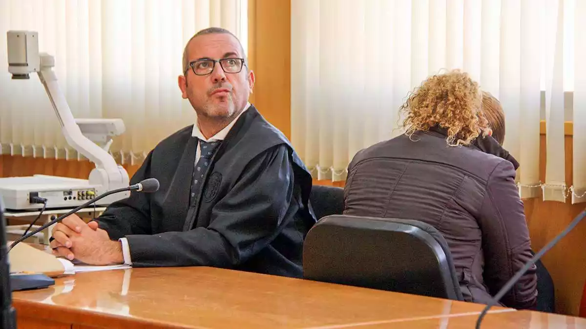 Pla mitjà de l'acusada d'intentar matar l'exparella, d'esquenes, a l'Audiència de Tarragona al costat del seu advocat, Ramon Martínez