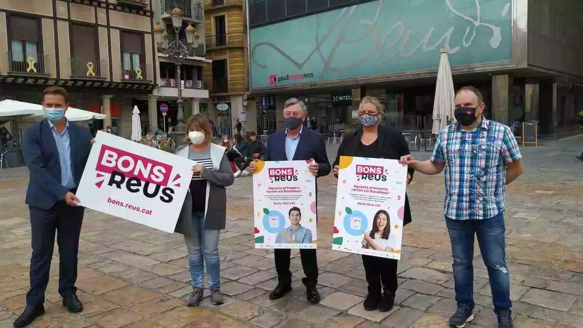 Representants d'entitats comercials i de l'Ajuntament mostrant els cartells de la nova campanya de Bons Reus davant del Gaudí Centre