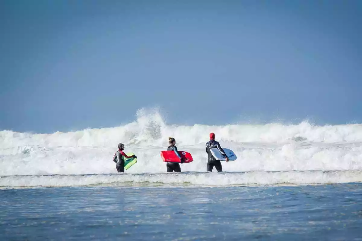 Tres persones fent surf