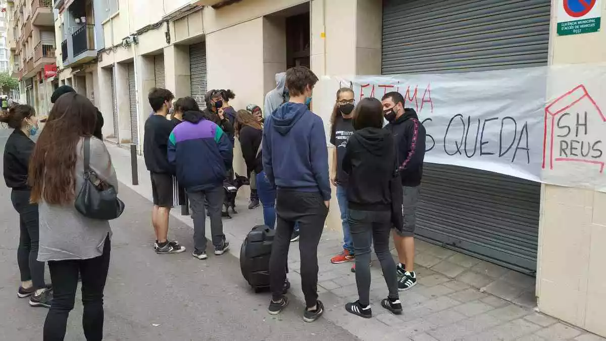 Un grup de persones davant del número 41 del carrer de Sant Magí de Reus, amb una pancarta del Sindicat d'Habitatge