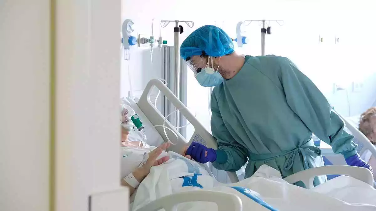 Un professional sanitari atén un pacient al nou espai polivalent de l'Hospital de Bellvitge el 26 de gener del 2021