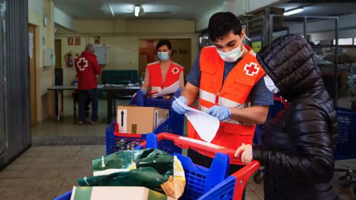 Imatge del personal de la Creu Roja Tarragona durant el repartiment d'aliments