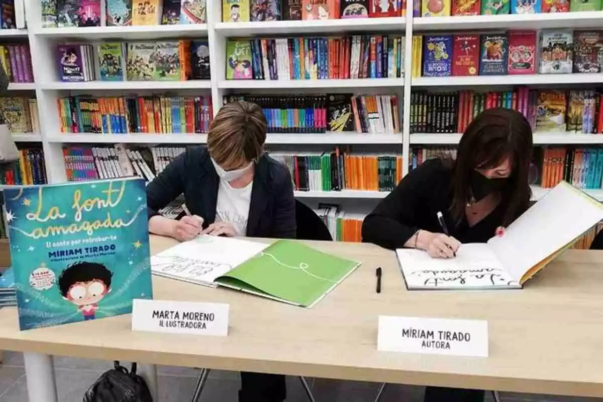 Miriam Tirado i Marta Moreno a una signatura de llibres