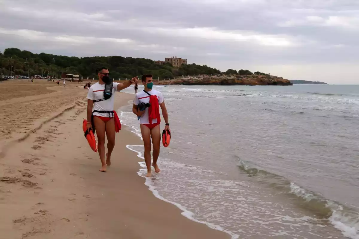 Pla general de dos socorristes fent tasques de vigilància a la platja de l’Arrabassada de Tarragona