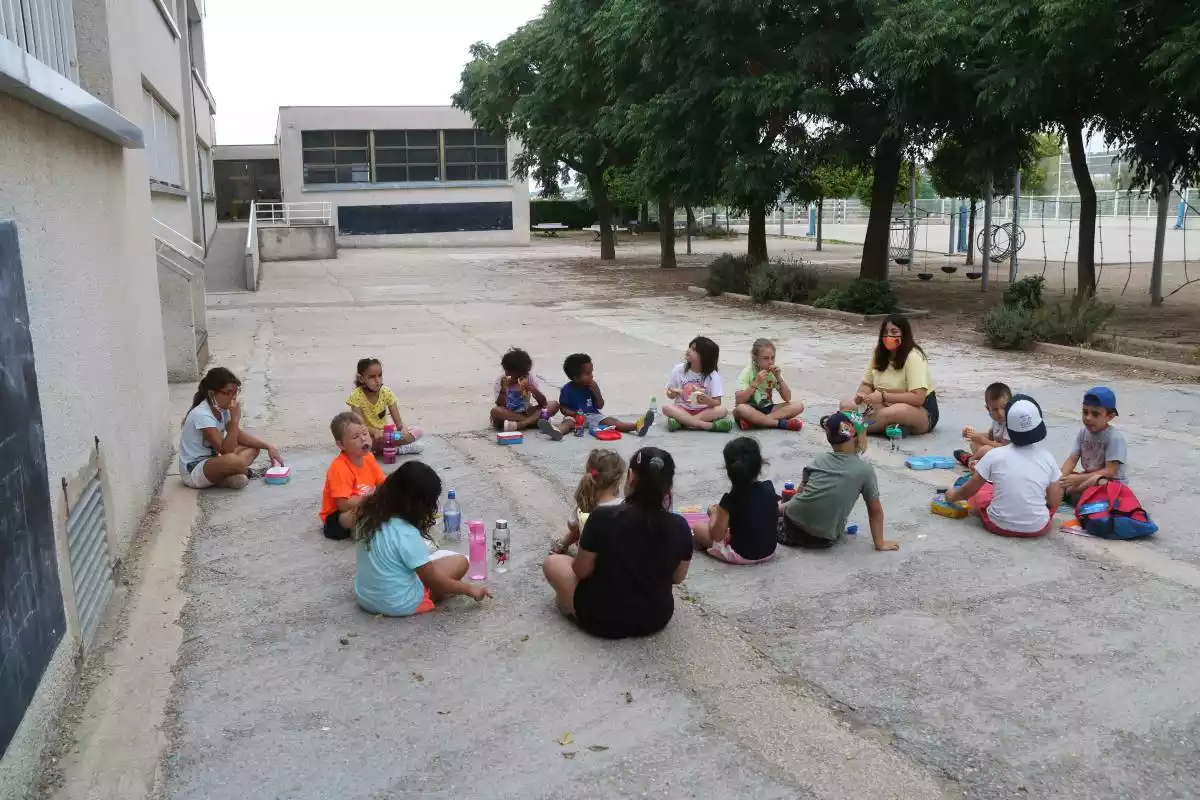 Pla general d'una rotllana de nens i nenes que participen al casal d'estiu de la Fundació Pere Tarrés a Torredembarra