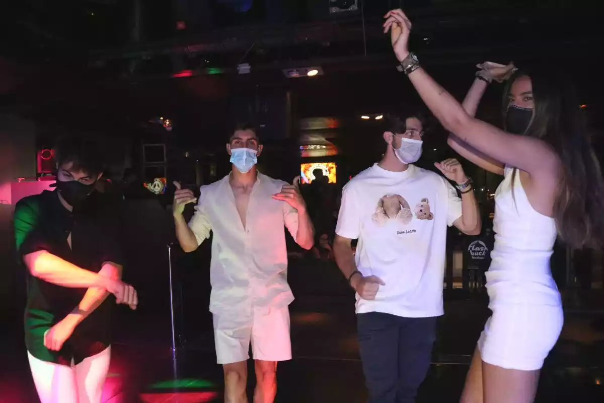 Pla mig d'un grup de joves que balla amb mascareta a la pista de la discoteca Flashback de Salou
