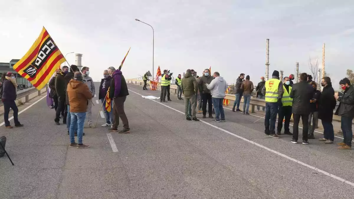 Pla obert d'un grup de treballadors d'IQOXE concentrats a l'entrada de l'empresa durant la jornada de vaga del 30 de març del 2021