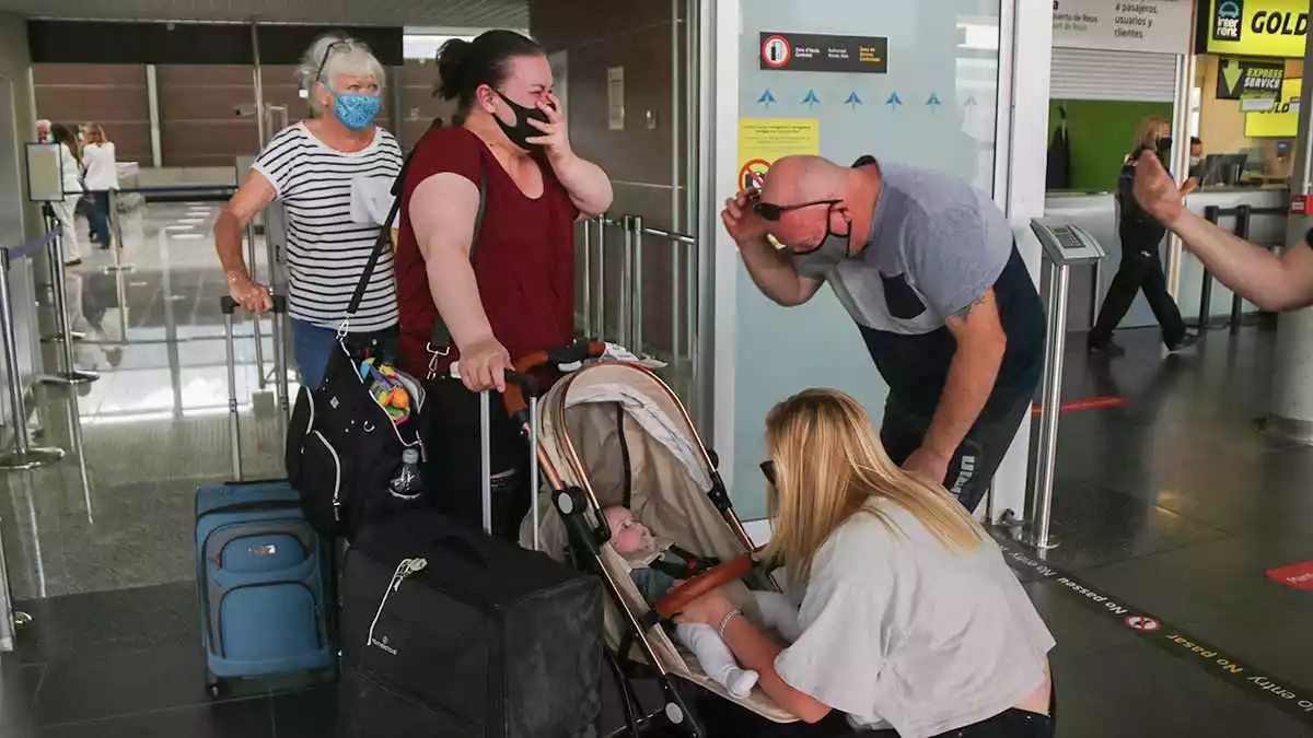 Pla obert d'una família que aterra a Reus després de mesos sense veure's i que coneix a la fillola per primer cop
