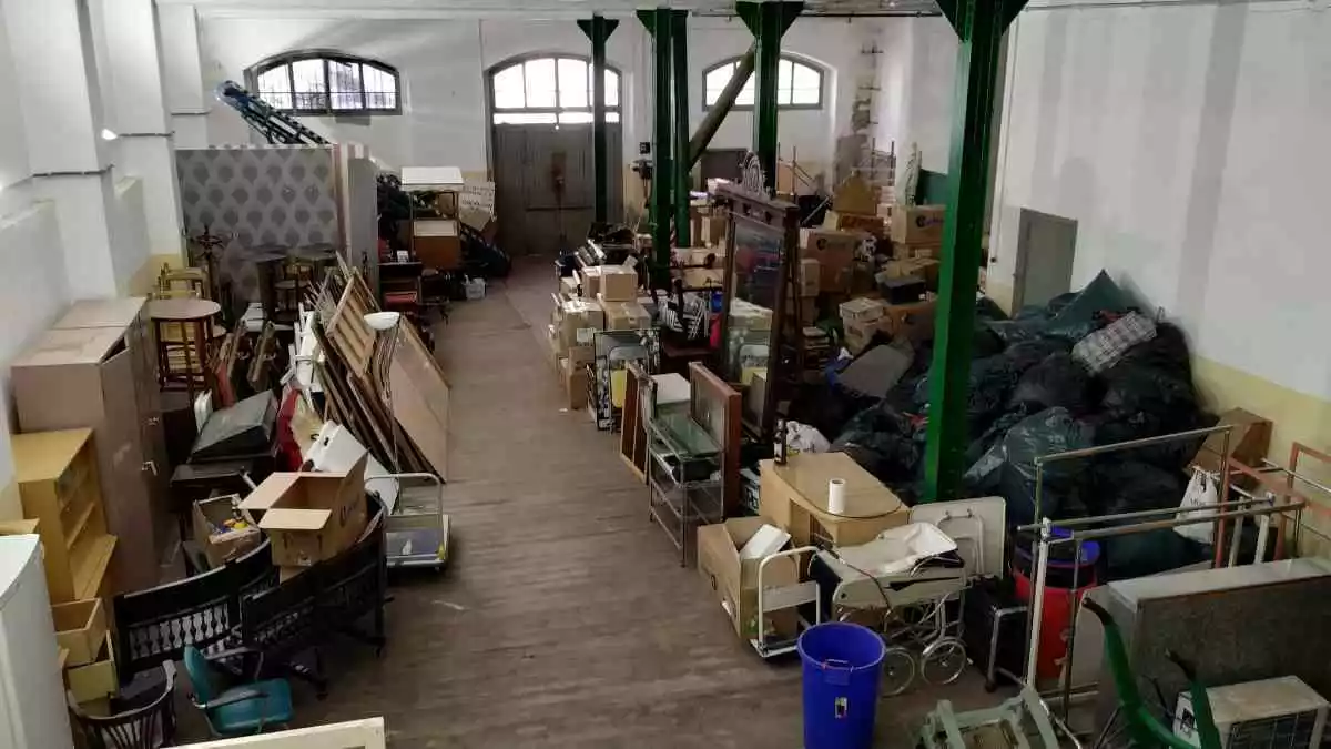 Un magatzem ple de capses, bosses, mobles i material
