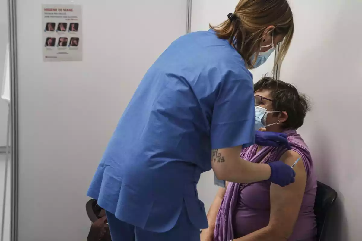 Una infermera administrant una vacuna a una senyora