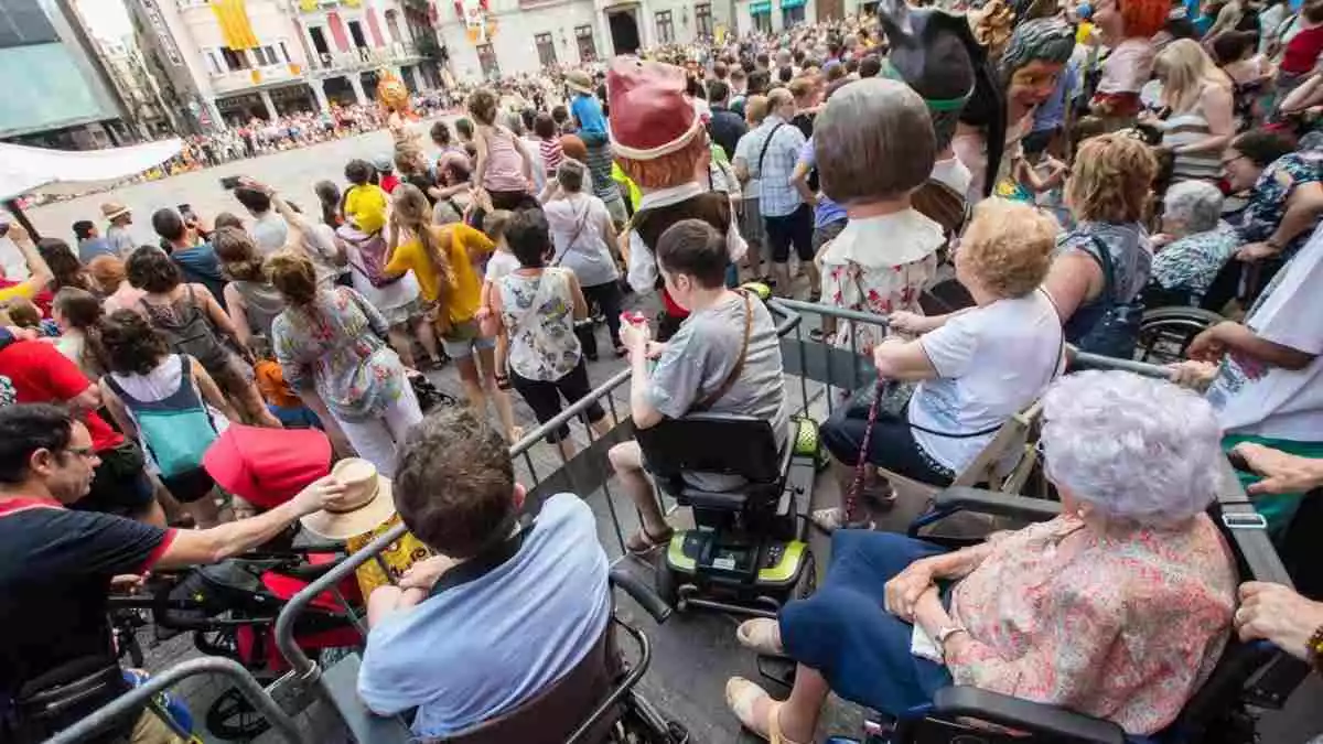 Una tarima instal·lada a la plaça del Mercadal amb persones amb cadira de rodes