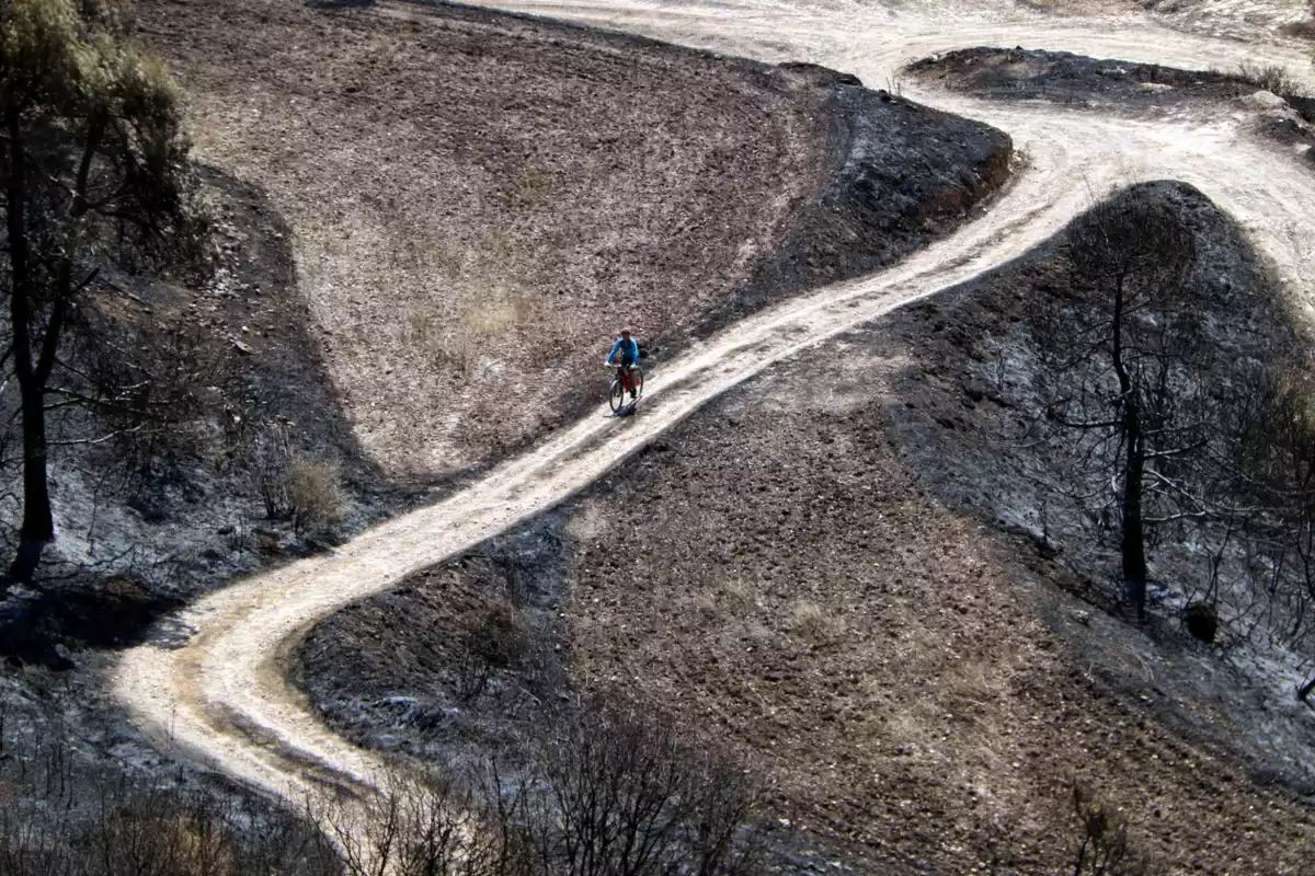 Un ciclista pujant pel camí d'accés al castell de Queralt