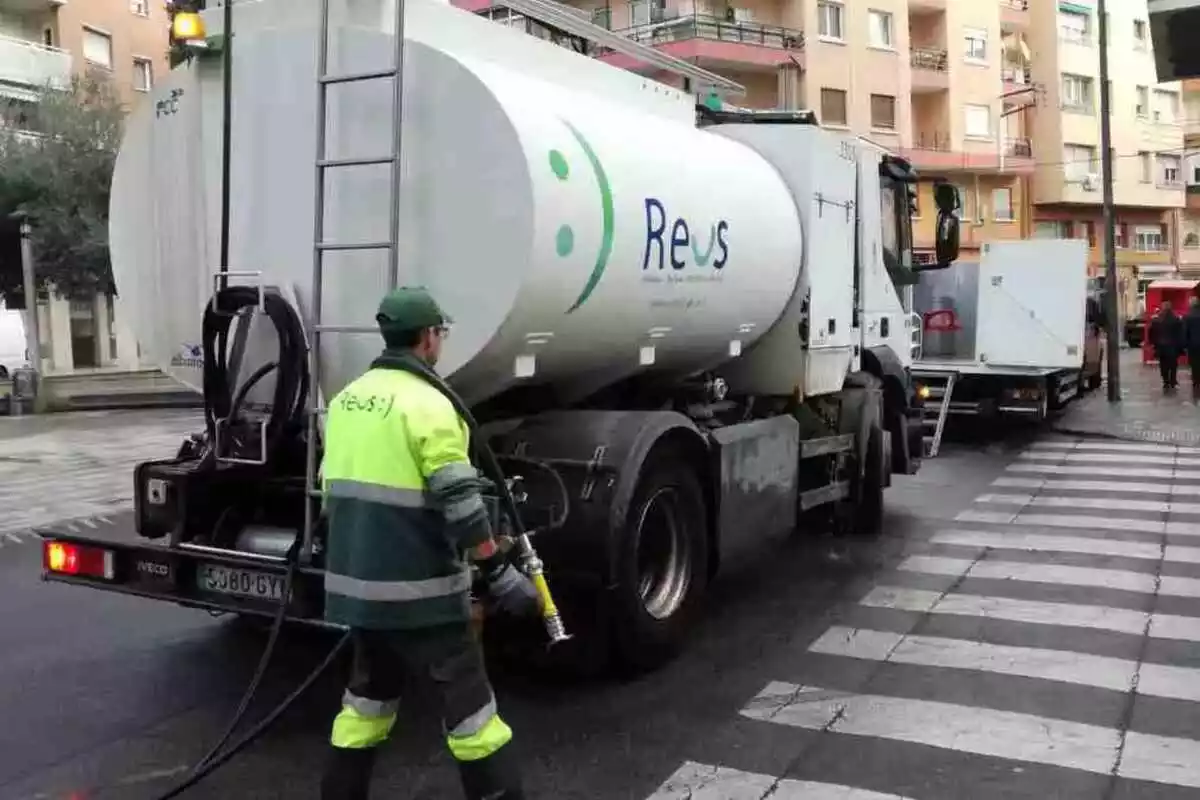Un operari al costat d'un camió cisterna del servei de la neteja viària de Reus